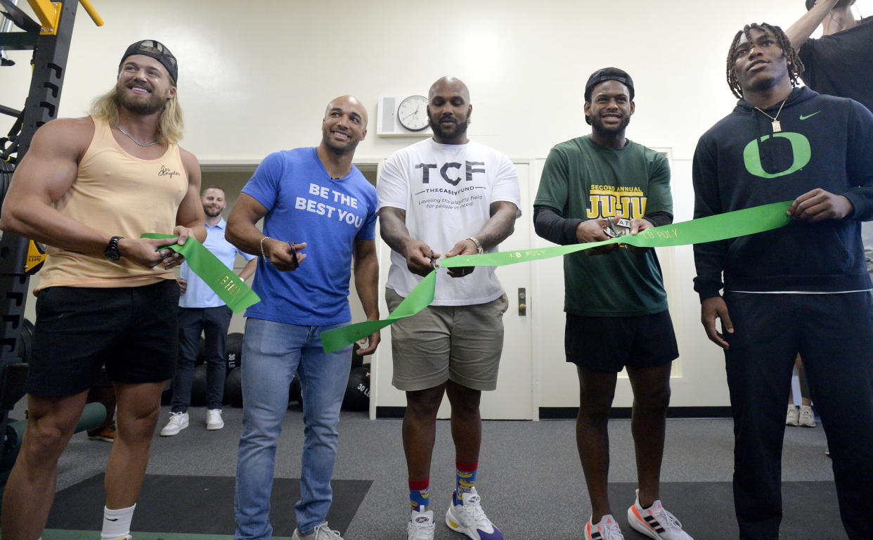 Los Angeles Chargers running back Austin Ekeler (second from left), is joined by former NFL player Jurrell Casey (center) and New England Patriots receiver JuJu Smith-Schuster (second from right) at an event unveiling a new weightlifting gym at Long Beach Poly High School in Long Beach. (Brittany Murray/MediaNews Group/Long Beach Press-Telegram via Getty Images)