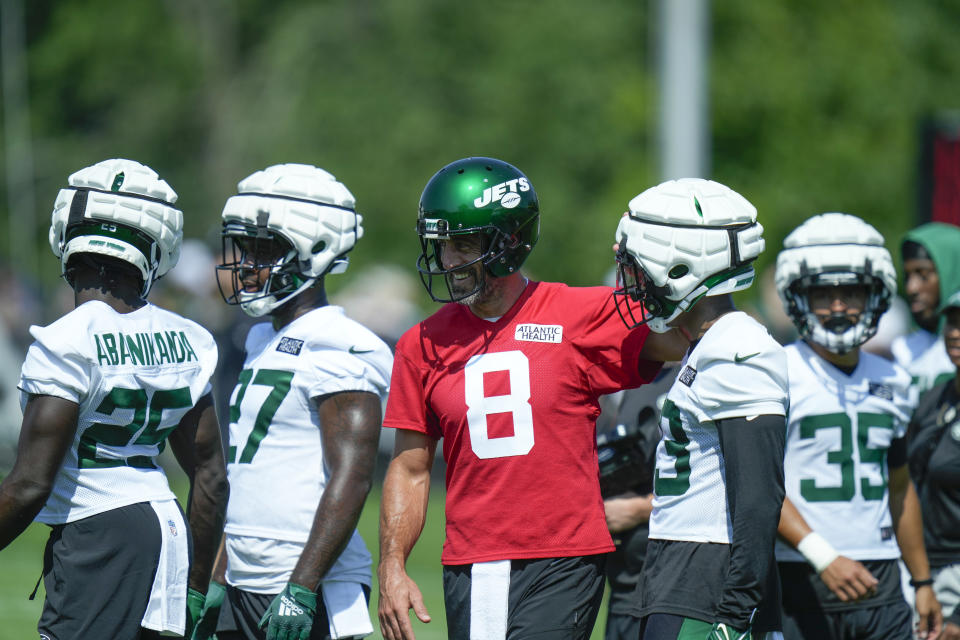 New York Jets quarterback Aaron Rodgers (8), center, talks with teammates at the NFL football team's training facility in Florham Park, N.J., Sunday, July 23, 2023. (AP Photo/Seth Wenig)