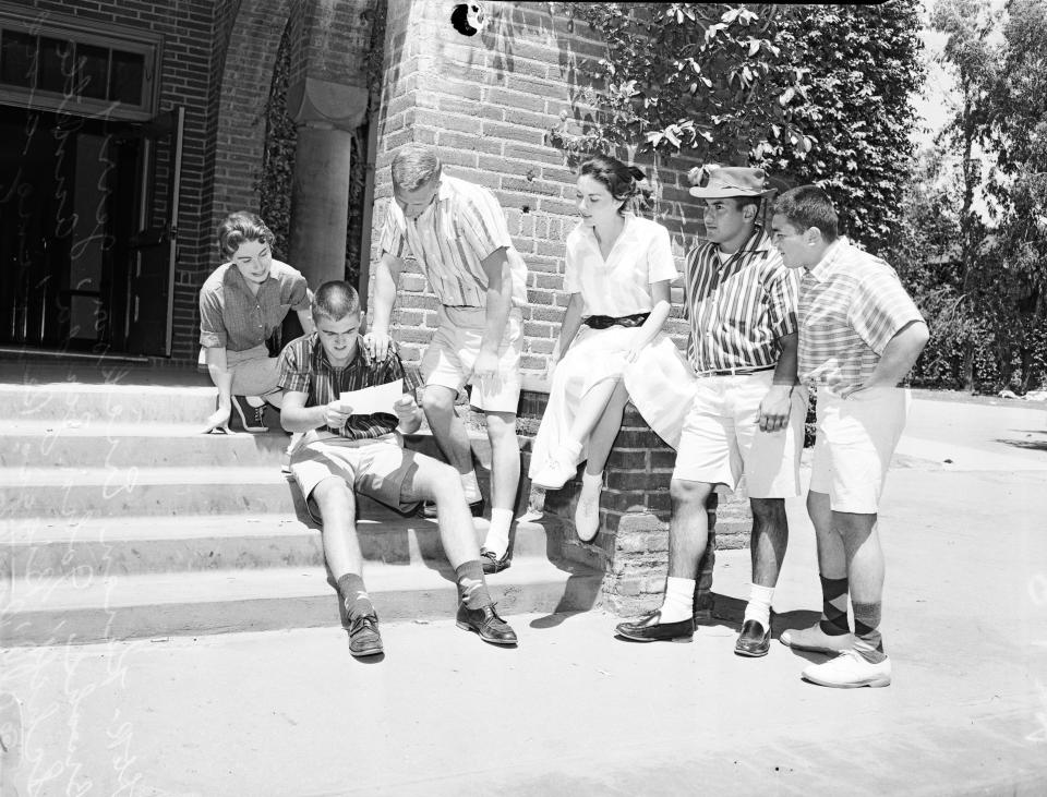 From left to right: Students at Los Angeles City College in 1958, Karen Erickson, 19; John Zinda, 20; Annette Schiff, 19; Biggio Pennino, 21; and Al Ponce, 19, look on as Jerry Brooks, 18 (second from left), reads a campus order instructing students not to wear shorts. (Photo by USC Libraries/Corbis via Getty Images)