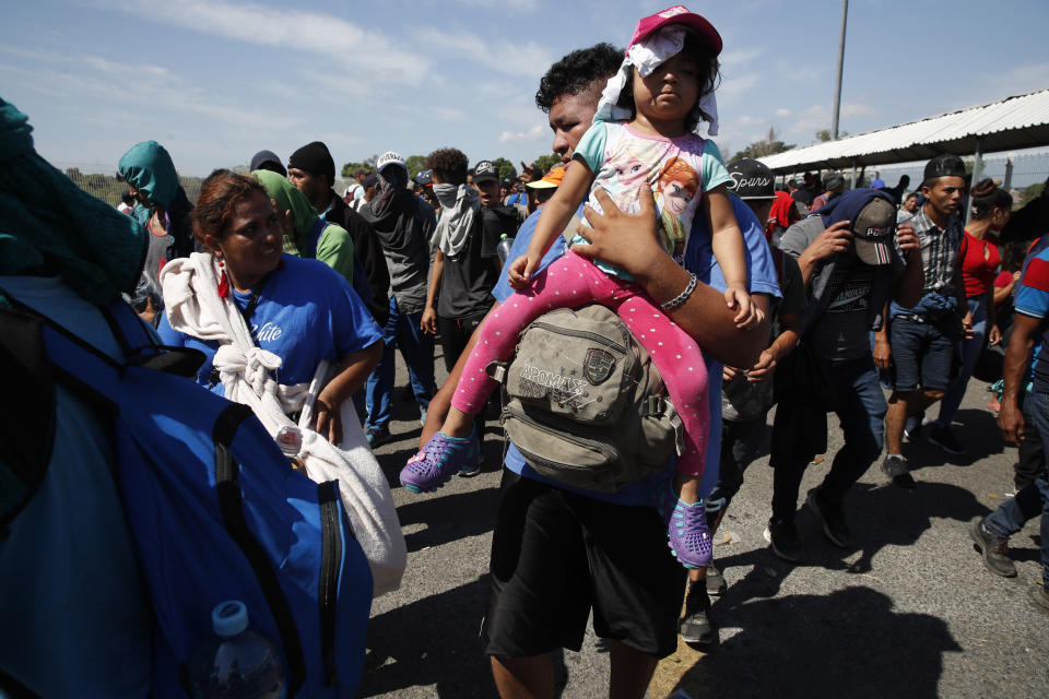 Central American migrants leave the border bridge to instead cross the Suchiate River by foot from Tecun Uman, Guatemala, Monday, Jan. 20, 2020. More than a thousand Central American migrants hoping to reach United States marooned in Guatemala are walking en masse across a river leading to Mexico in an attempt to convince authorities there to allow them passage through the country. (AP Photo/Moises Castillo)