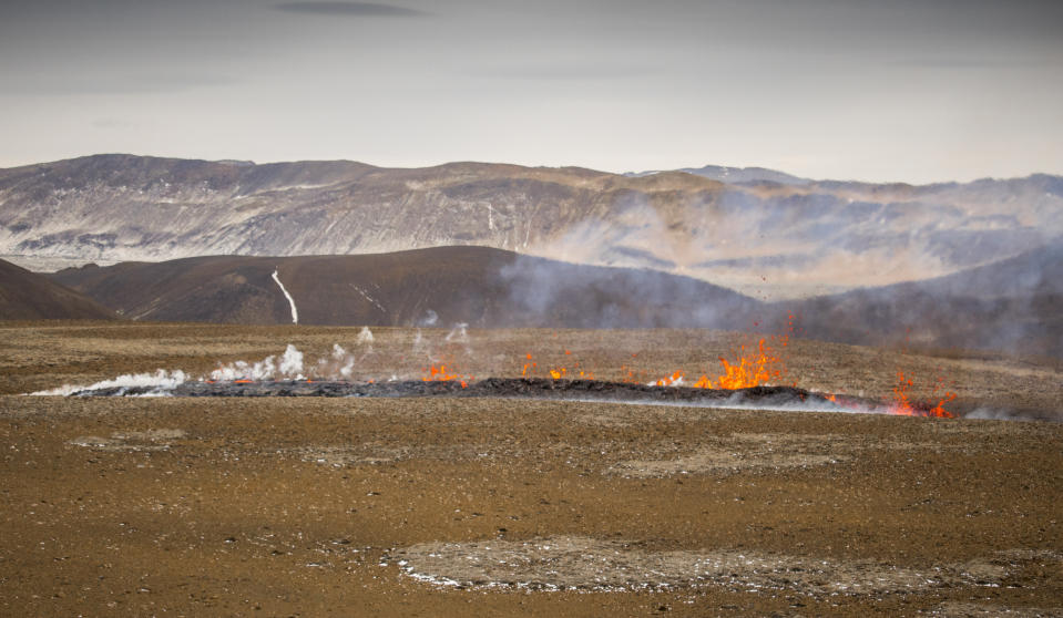 Steam and lava spurt from a new fissure on a volcano on the Reykjanes Peninsula in southwestern Iceland, Monday, April 5, 2021. The new fissure has opened up at the Icelandic volcano that began erupting last month, prompting the evacuation of hundreds of hikers who had come to see the spectacle. Officials say the new fissure is about 500 meters (550 yards) long and about one kilometer (around a half-mile) from the original eruption site in the Geldinga Valley (AP Photo/Marco Di Marco)