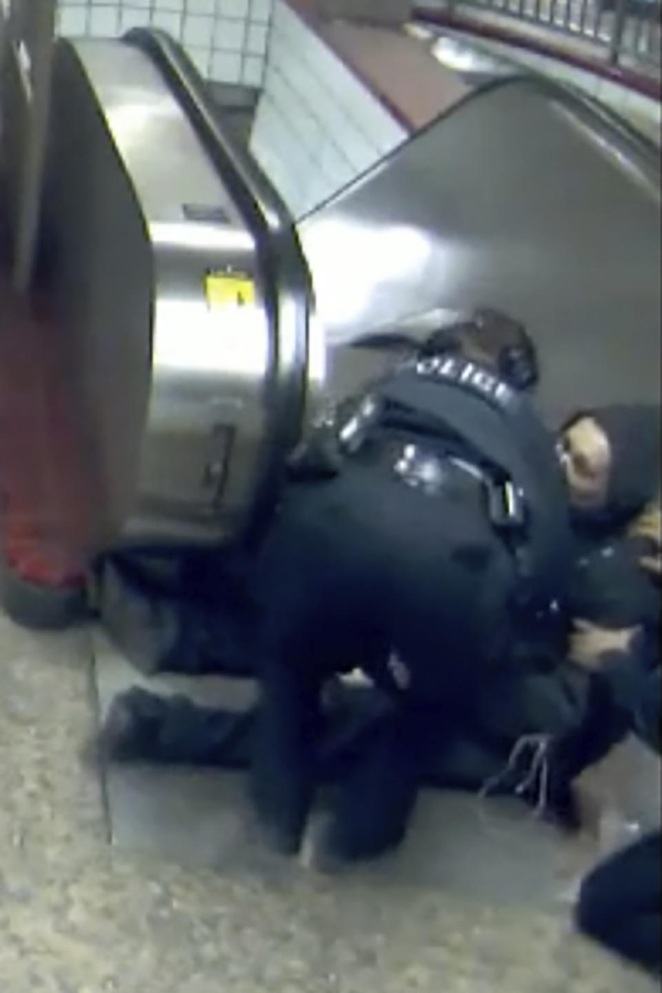 In this Feb. 28, 2020 image from video provided by the Civilian Office of Police Accountability, police officers tend to Ariel Roman after he was shot by police in a subway station in Chicago. Extended security and body-cam video released Tuesday, April 28, 2020 shows Chicago police shooting the unarmed short-order cook at the foot of a subway escalator and then again with his back turned to officers after they tried to stop him for violating a city ordinance by walking from one train car to another. (Chicago Transit Authority, Civilian Office of Police Accountability via AP)