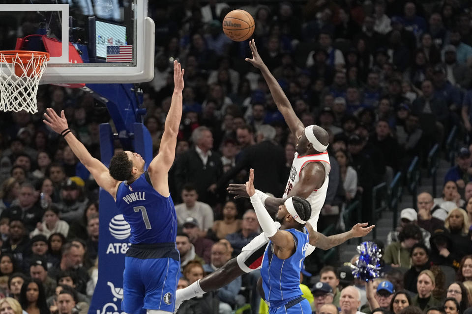 Portland Trail Blazers center Duop Reath, top right, shoots against Dallas Mavericks defenders Dwight Powell (7) and guard Jaden Hardy, bottom right, during the first half of an NBA basketball game in Dallas, Friday, Jan. 5, 2024. (AP Photo/LM Otero)