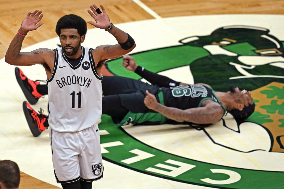 Brooklyn Nets guard Kyrie Irving (11) gestures after fouling Boston Celtics guard Marcus Smart (36) who celebrates his 3-point basket during the third quarter of Game 3 of an NBA basketball first-round playoff series Friday, May 28, 2021, in Boston. (AP Photo/Elise Amendola)