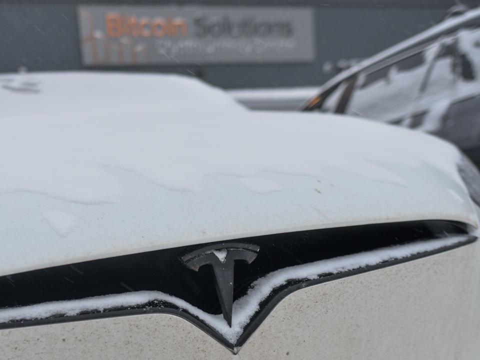 Tesla logo seen on a Tesla car covered with snow in Edmonton.