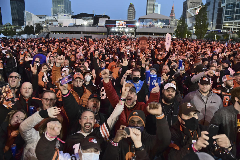 Cleveland Browns fans celebrate the second round pick, Jeremiah Owusu-Koramoah, linebacker for Notre Dame, at the NFL football draft, Friday, April 30, 2021, in Cleveland. (AP Photo/David Dermer)