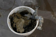 A discarded lead pipe is shown after crews replaced with copper fixtures at a home in Royal Oak, Mich., on Tuesday, Nov. 16, 2021. Communities with lead pipes could see higher test results for lead in their tap water if a new method of water sampling goes into effect. The Detroit suburb of Royal Oak historically had low test results but it had to notify the public of a problem after the state mandated new sampling methods. (AP Photo/Carlos Osorio)