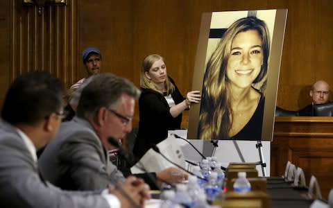 A photo of Kate Steinle is placed on an easel in court as her father Jim Steinle (2nd L) prepares to testify  - Credit: Reuters