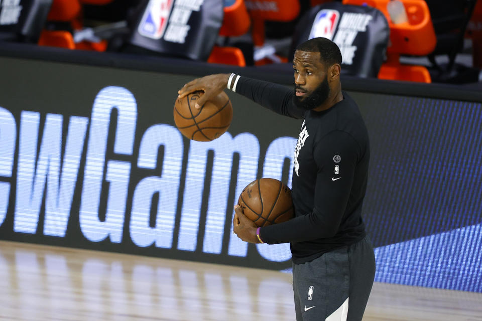 LeBron James holds two basketballs.