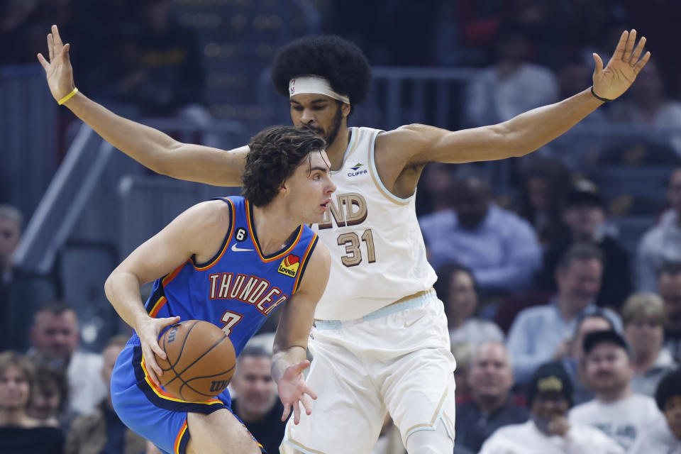 Oklahoma City Thunder guard Josh Giddey (3) drives against Cleveland Cavaliers center Jarrett Allen (31) during the first half of an NBA basketball game, Saturday, Dec. 10, 2022, in Cleveland. (AP Photo/Ron Schwane)