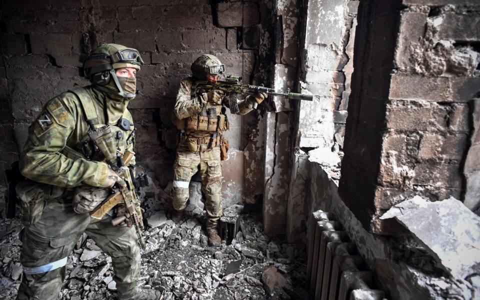 Russian soldiers patrol at the Mariupol drama theatre, as Russian troops intensify a campaign to take the strategic port city - ALEXANDER NEMENOV/AFP