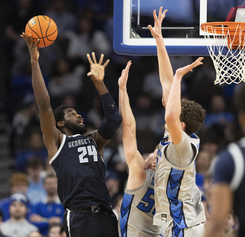 Georgetown's Supreme Cook shoots against Creighton's Baylor Scheierman and Ryan Kalkbrenner, right, during the second half of an NCAA college basketball game Tuesday, Feb. 13, 2024, in Omaha, Neb. (AP Photo/Rebecca S. Gratz)