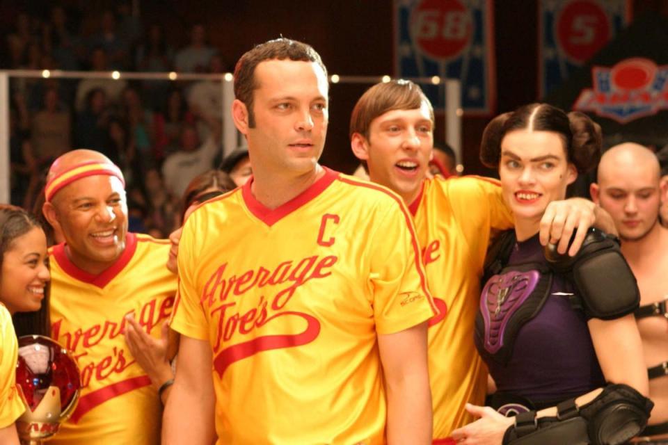 dodgeball a true underdog story cast all wearing their sports outfits, with vince vaughn in the middle