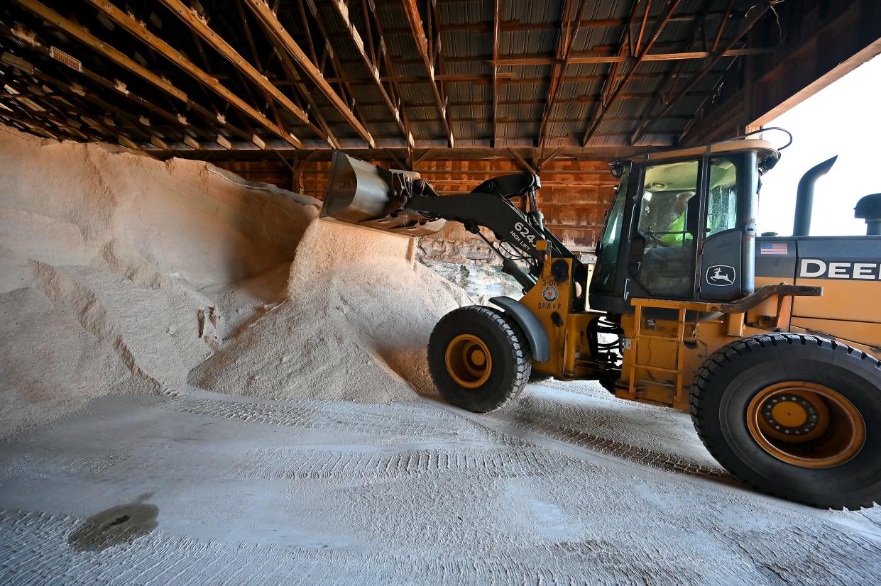 Paul Snape uses an excavator to move road salt further back in the salt shed at the Worcester Department of Public Works & Parks on Albany Street Friday.
