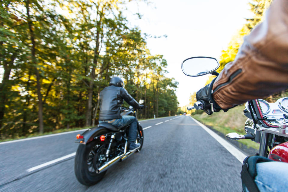 Two people riding motorcycles on the highway.