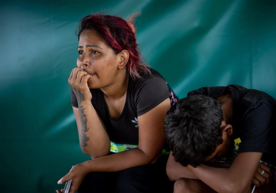 Migrants may spend weeks or months, and sometimes even longer, waiting in camps in Necoclí, until they can afford travel into the Darién. Here, Venezuelan migrants Genesis Madeleines Gonzalez Perez and her son, Aaron Jose Gonzalez Perez, 13, pass their time in a shade tent in the migrant camp. | Spenser Heaps, Deseret News