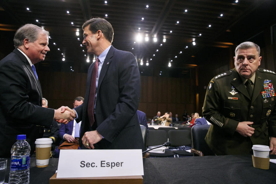 Defense Secretary Mark Esper, center, shakes hands with Sen. Doug Jones, D-Ala., as Esper and Chairman of the Joint Chiefs of Staff Gen. Mark Milley, right, arrive to testify to the Senate Armed Services Committee about the budget, Wednesday, March 4, 2020, on Capitol Hill in Washington. (AP Photo/Jacquelyn Martin)