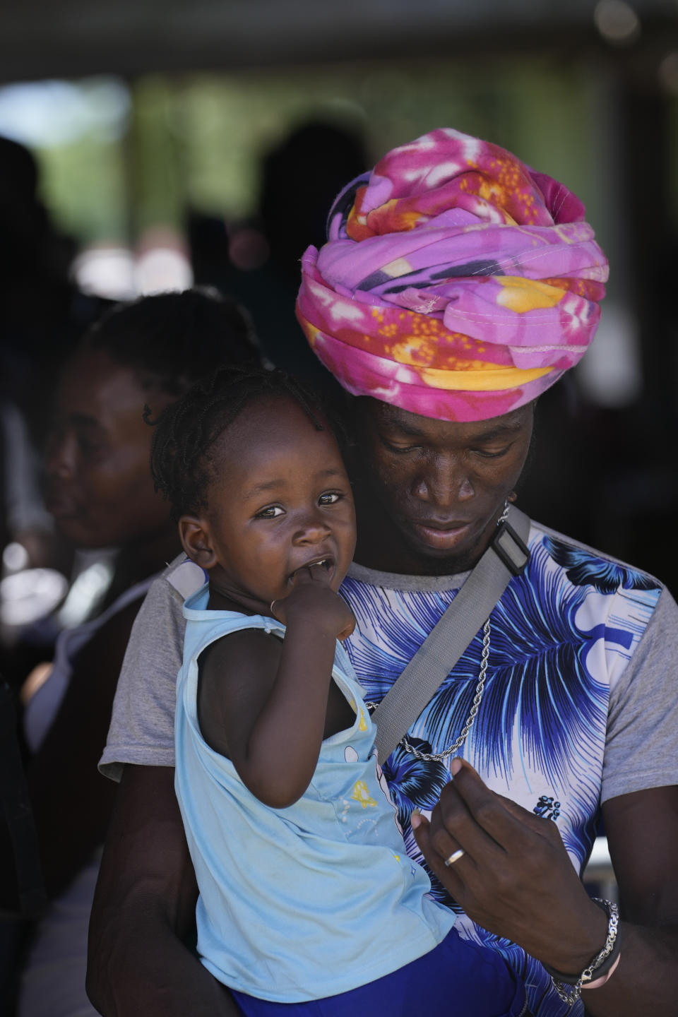 Migrants, many from from Haiti, stand in line to board a bus that will transport them to another shelter on their journey through Panama, trying to reach the United States, in Lajas Blancas, Darien province, Panama, Friday, Oct. 1, 2021. (AP Photo/Arnulfo Franco)