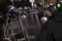 Riot police officers patrol during a protest against the government restriction measures to curb the spread of COVID-19, in Milan Italy, Monday, Oct. 26, 2020. Italy's leader has imposed at least a month of new restrictions to fight rising coronavirus infections, shutting down gyms, pools and movie theaters and putting an early curfew on cafes and restaurants. (AP Photo/Luca Bruno)