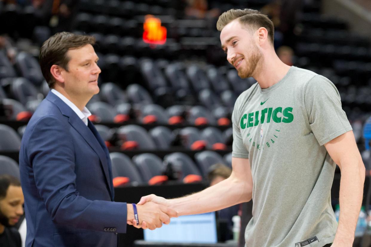 Utah Jazz general manager Dennis Lindsey, left, shakes hands with Boston Celtics forward Gordon Hayward before a game in Salt Lake City, Utah, Nov. 9, 2018.