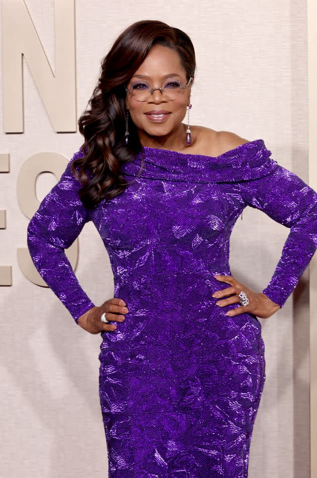Oprah Winfrey showed off her curves in a form-fitting long-sleeved purple gown.