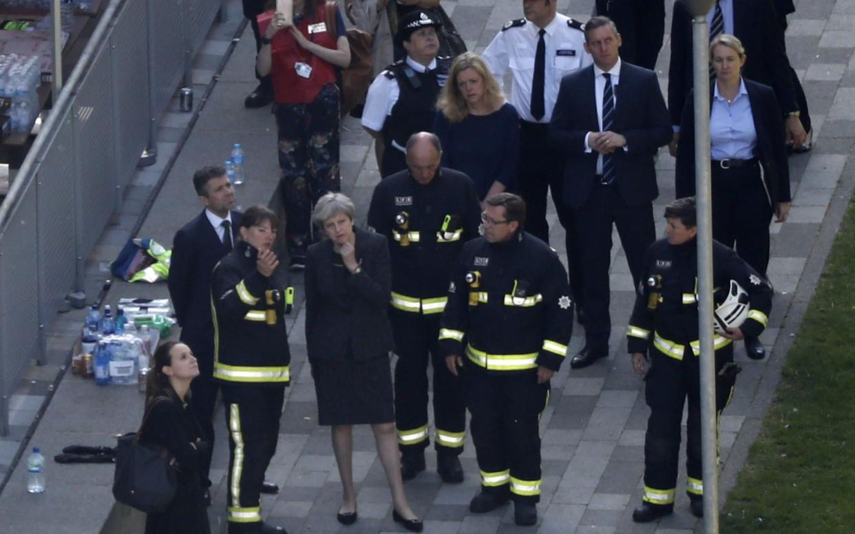 Dany Cotton (L), London Fire Brigade commissioner, talks to the Prime Minister as she visits the remains of Grenfell Tower on June 14 - AFP