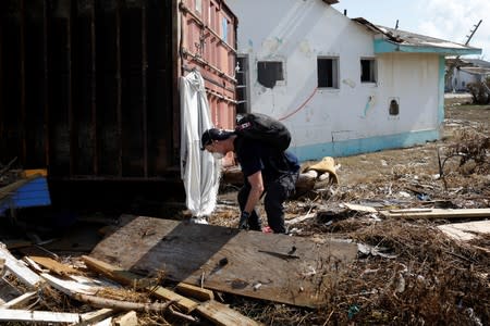 A member of the Canadian Burnaby Firefighters Search & Rescue Task Force searches for the dead in the destroyed the Mudd neighbourhood after Hurricane Dorian hit the Abaco Islands in Marsh Harbour