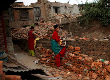 Women prepare to carry bricks from a collapsed house on the outskirts of Kathmandu, Nepal, May 15, 2015. REUTERS/Ahmad Masood