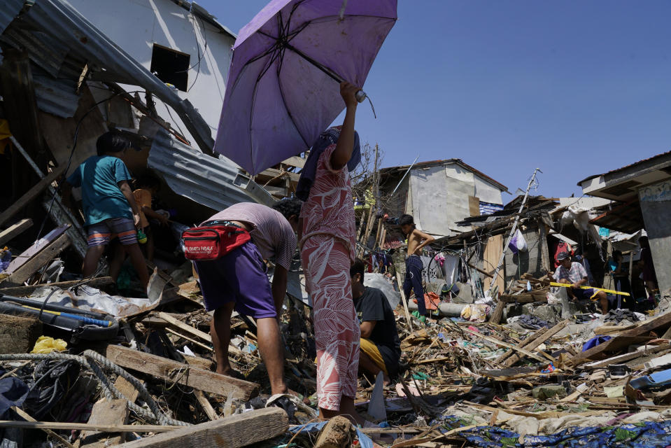 Residents salvage parts of their damaged homes following Typhoon Rai in Talisay, Cebu province, central Philippines on Saturday, Dec. 18, 2021. The strong typhoon engulfed villages in floods that trapped residents on roofs, toppled trees and knocked out power in southern and central island provinces, where more than 300,000 villagers had fled to safety before the onslaught, officials said. (AP Photo/Jay Labra)