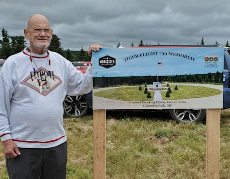 Clifton Sargent stands beside a rendering of the memorial to victims of Flight 739 in Calhoun Falls, Maine. His brother, Donald, was on the flight.