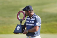 Bryson DeChambeau kisses the Rocket Mortgage Classic golf tournament trophy Sunday, July 5, 2020, at Detroit Golf Club in Detroit. DeChambeau won the tournament by three strokes for his first victory of the season and sixth overall. (AP Photo/Carlos Osorio)