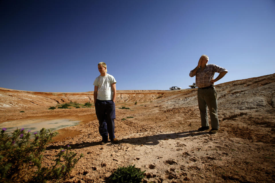 Farmer Frank Sibraa stands with his grandson at the bottom of an empty water reservoir in West Wyalong, New South Wales.