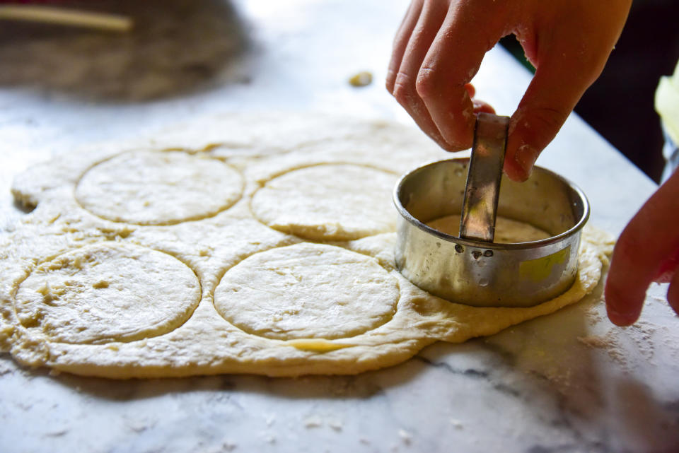 Cutting dough circles with cookie cutter.