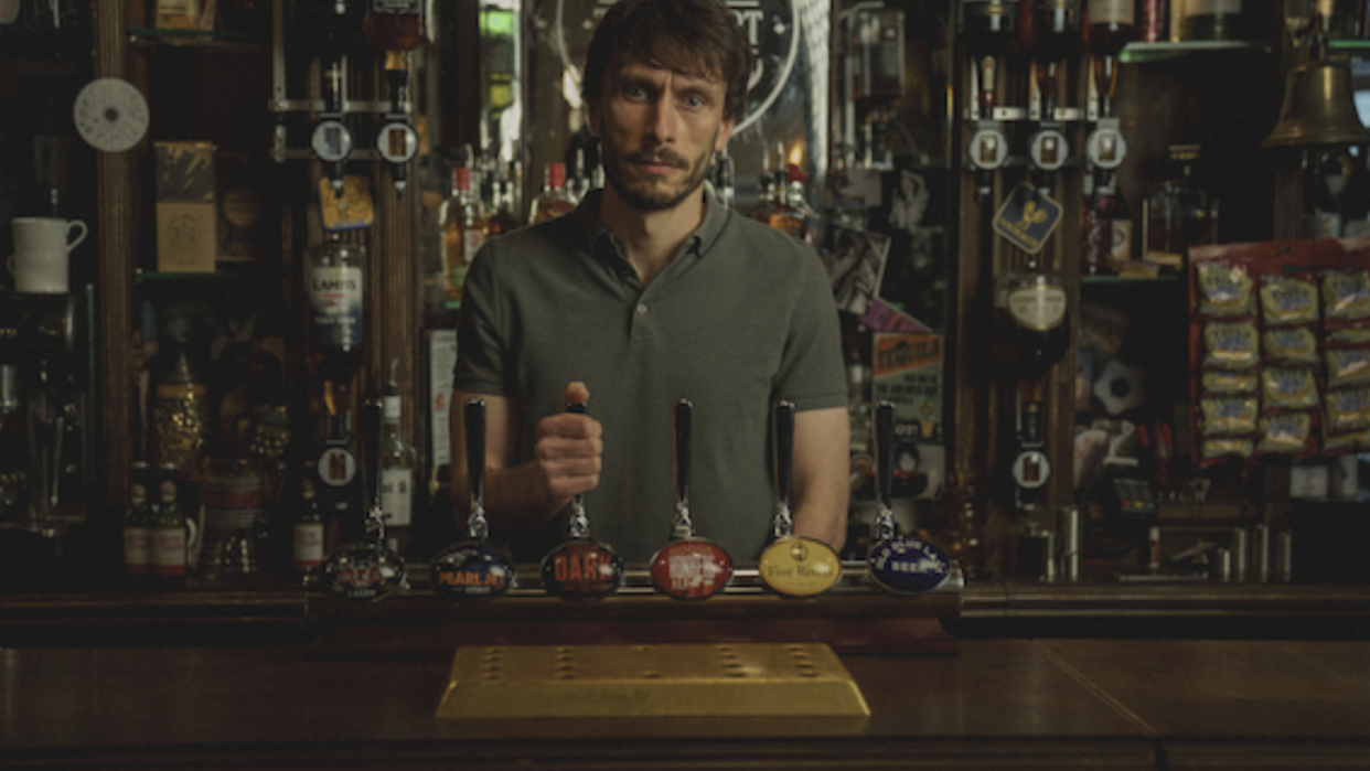 a man standing behind a bar