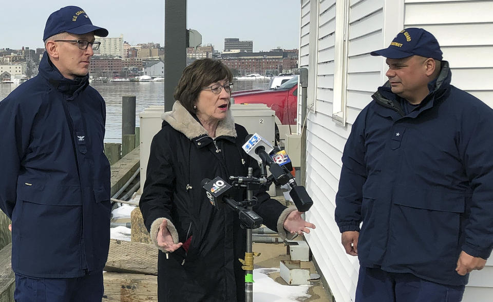FILE - In this Feb. 20, 2019, file photo, Sen. Susan Collins, R-Maine, is flanked by Coast Guard Capt. Brian LeFebvre, left, and Rear Adm. Andrew Tiongson, right, as she addresses reporters after the ribbon-cutting at a U.S. Coast Guard regional command center in South Portland, Maine. National money is already flowing into Maine’s 2020 Senate race, offering the latest indicator that incumbent Collins faces a stiff reelection fight. (AP Photo/David Sharp, File)