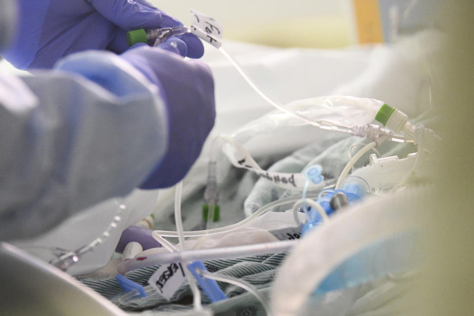 East Alabama Medical Center nurse Harvard Graham checks fluids for a COVID-19 patient in the intensive care unit Thursday, Dec. 10, 2020, in Opelika, Ala. The medical center faces a new influx of COVID-19 patients as the pandemic intensifies. (AP Photo/Julie Bennett)