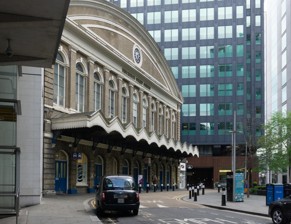 View of fron of Fenchurch street station on a weekend when it is shut as it serves weekday commuter traffic. The building dates back to 1850's. A black London taxi is stopped outside