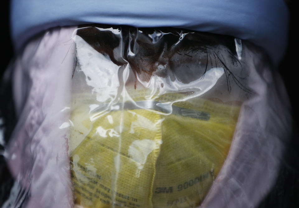 Nhuja Kaiju, of the RNA-16 volunteer group, wearing protective suit assists a nurse at a hospital in Bhaktapur, Nepal, Tuesday, May 26, 2020. RNA-16 stands for “Rescue and Awareness” and the 16 kinds of disasters they have prepared to deal with, from Nepal’s devastating 2015 earthquake to road accidents. But the unique services of this group of three men and a woman in signature blue vests in the epidemic amount to a much greater sacrifice, said doctors, hospital officials and civic leaders. (AP Photo/Niranjan Shrestha)