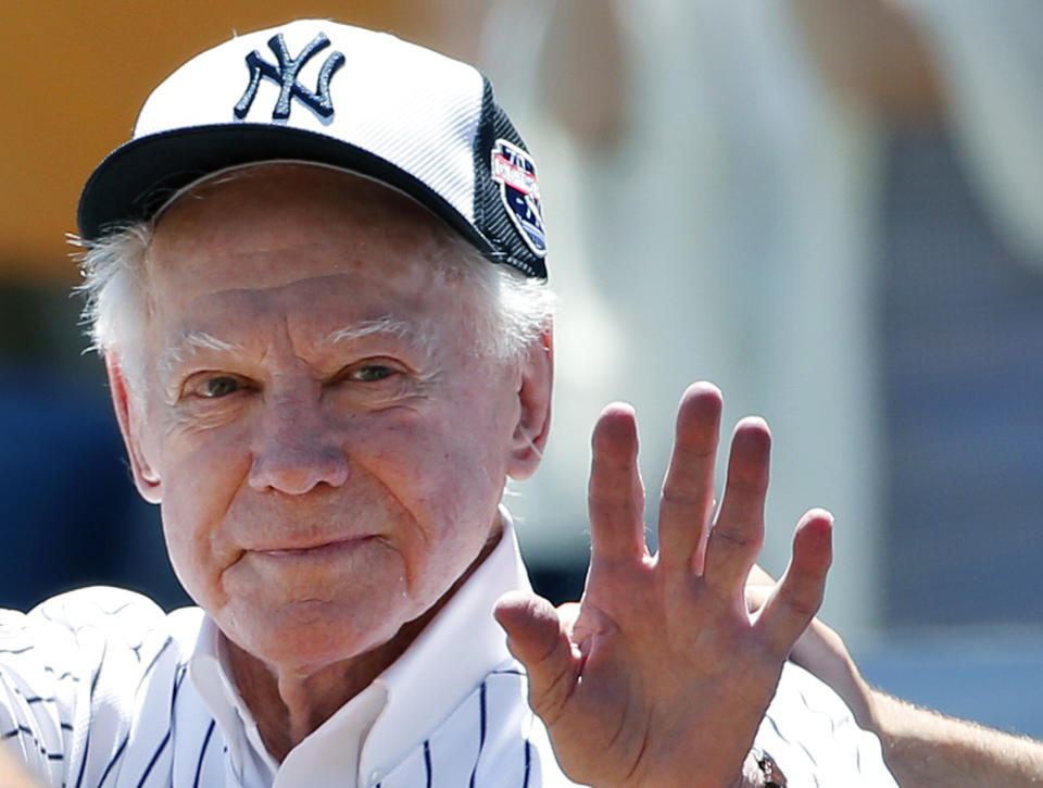 FILE - In this June 12, 2016 file photo, former New York Yankees pitcher Whitey Ford waves to fans from outside the dugout at the Yankees' annual Old Timers Day baseball game in New York. A family member tells The Associated Press on Friday, Oct. 9, 2020 that Ford died at his Long Island home Thursday night. (AP Photo/Kathy Willens, File)