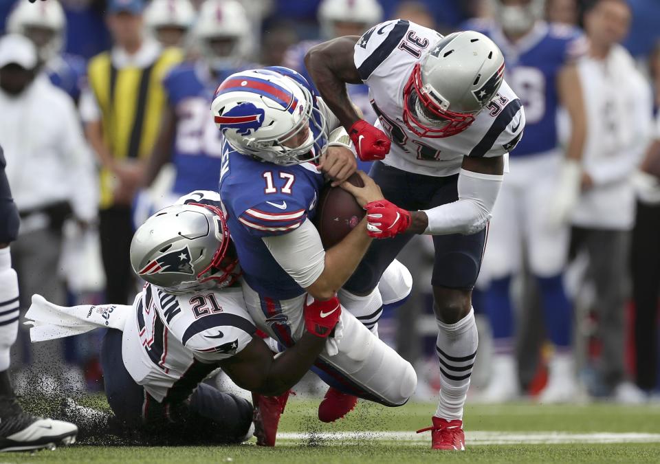 New England Patriots defenders Jonathan Jones (31) and Duron Harmon (21) tackle Buffalo Bills quarterback Josh Allen (17) in the second half of an NFL football game, Sunday, Sept. 29, 2019, in Orchard Park, N.Y. Allen left the field after the play. (AP Photo/Ron Schwane)