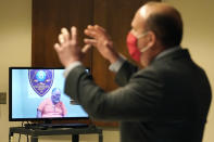 Defendant Gordon Searles appears on video for a bail hearing as Defense Attorney Joe Fricano, right, speaks at Manchester, N.H. District Court, Monday, April 12, 2021, in connection with sexual abuse allegations at the Sununu Youth Services Center, a state-run youth detention center. (AP Photo/Elise Amendola, Pool)