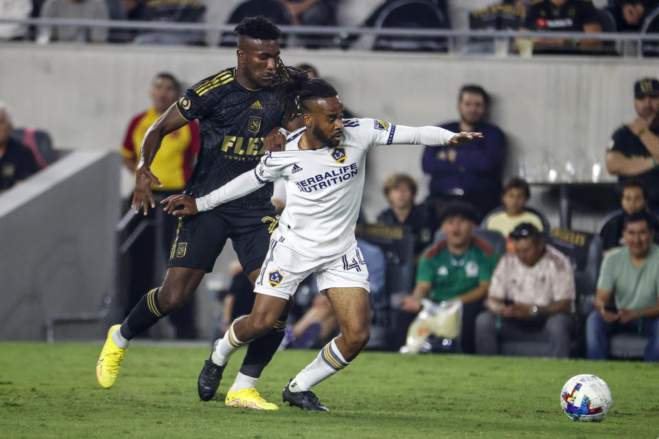 Los Angeles FC's Jose Cifuentes, left, and LA Galaxy forward Raheem Edwards vie for the ball during the first half of an MLS playoff soccer match Thursday, Oct. 20, 2022, in Los Angeles. (AP Photo/Ringo H.W. Chiu)