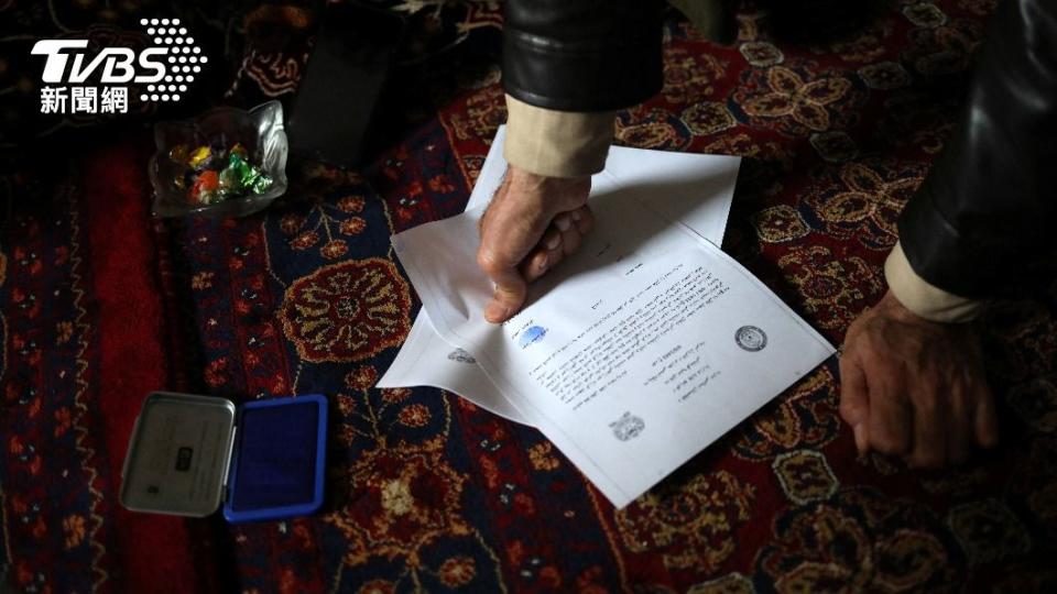 雙方在協議上蓋上手印，由塔利班警方見證。（圖／達志影像路透社）