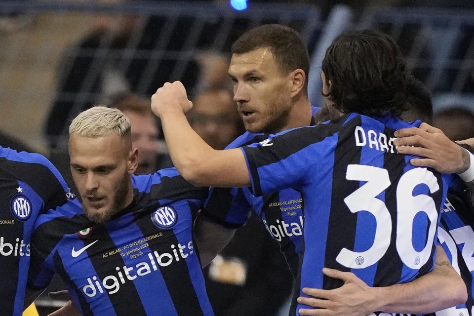 Inter Milan's Edin Dzeko, center, celebrates with his teammates Federico Dimarco, left, and Matteo Darmian after scoring his side's second goal during the Italian Super Cup final soccer match between AC Milan and Inter Milan at the King Saud University Stadium, in Riyadh, Saudi Arabia, Wednesday, Jan. 18, 2023. (AP Photo/Hussein Malla)