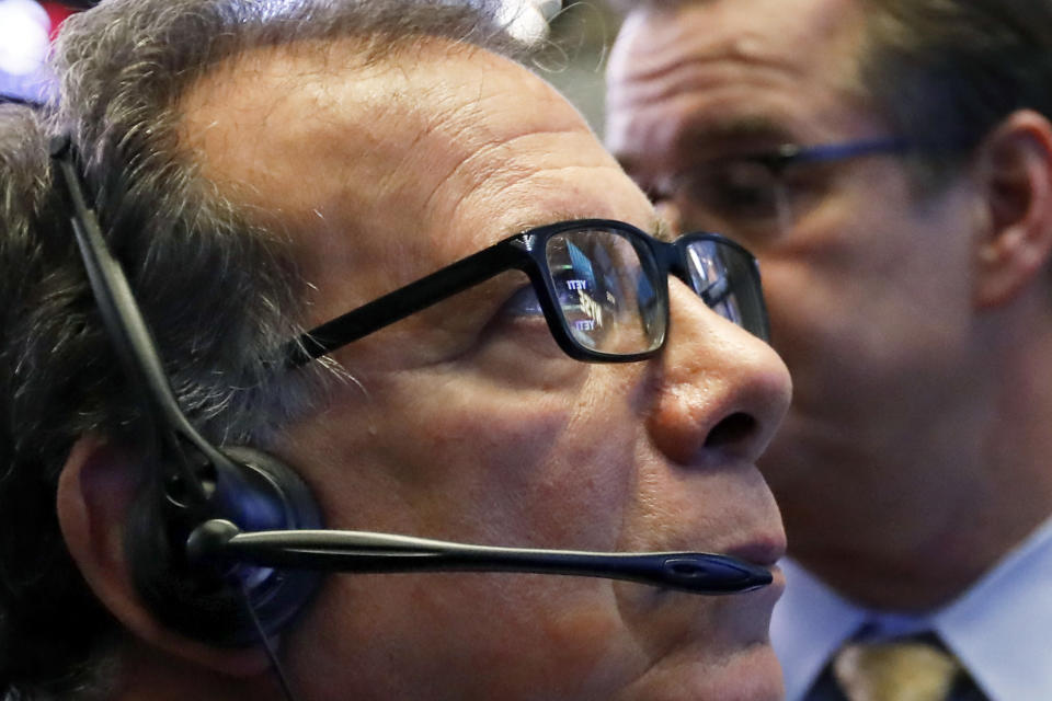 FILE- In this Oct. 25, 2018, file photo the NYSE and Yeti logos are reflected in the glasses of trader Sal Suarino as he works on the floor of the New York Stock Exchange. The U.S. stock market opens at 9:30 a.m. EDT on Thursday, Nov. 1. (AP Photo/Richard Drew, File)