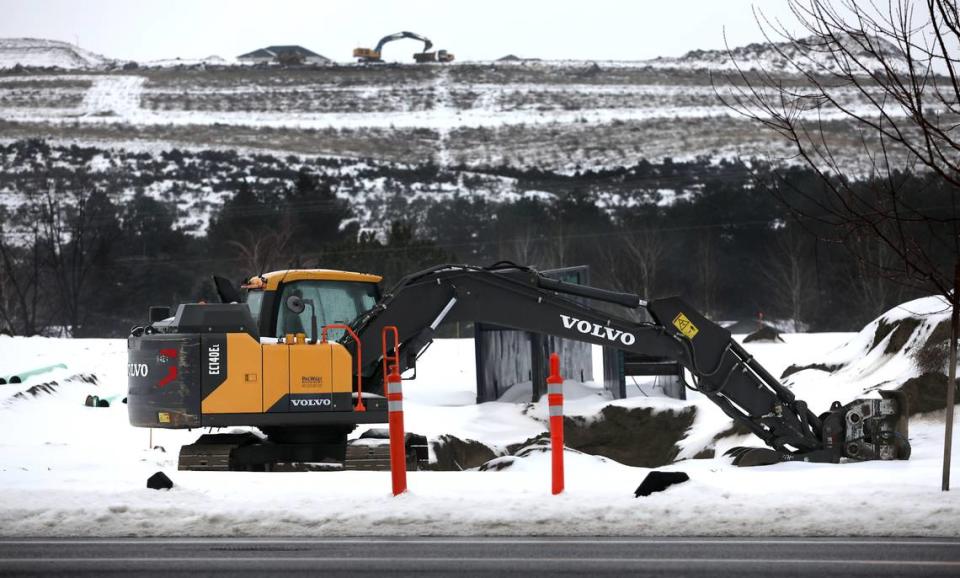 An excavator sits idle on snow covered former pasture land, the site of a new housing development called Shade Tree Subdivision, on West 10th Avenue just west of Columbia Center Boulevard in Kennewick. The excavator in the background is working on a housing develpment on Thompson Hill.