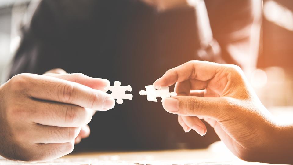 Businessman team work holding pieces two jigsaw connecting couple puzzle piece for matching to goals target, success and start up new project in office.