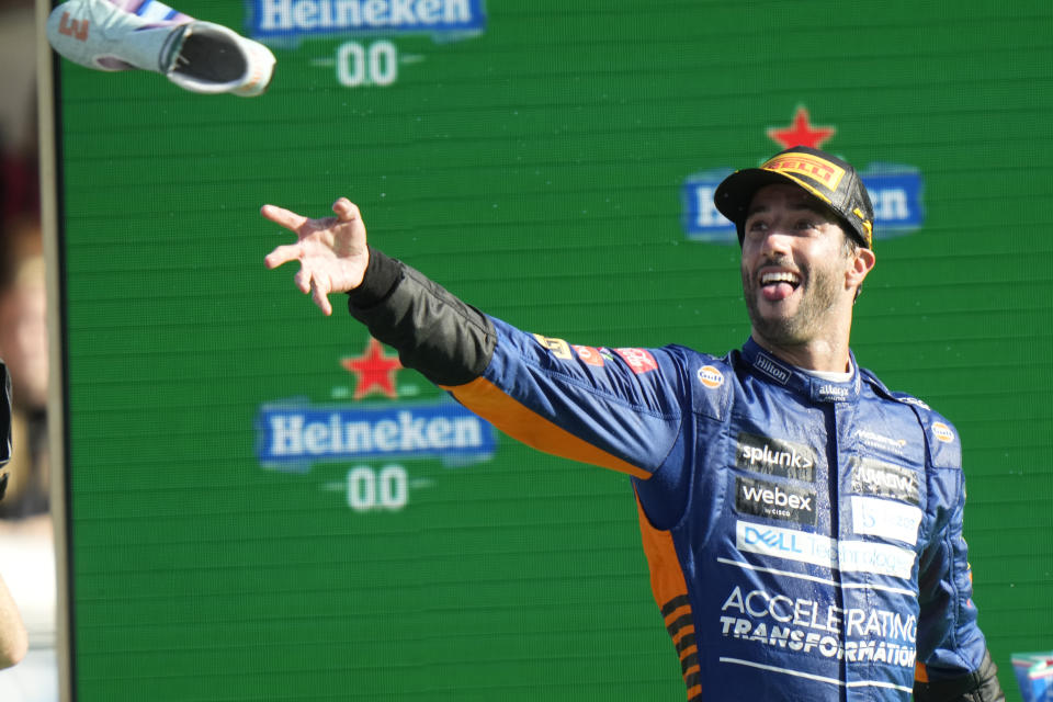 Mclaren driver Daniel Ricciardo of Australia throws his shoe as he celebrates after winning the Italian Formula One Grand Prix, at Monza racetrack, in Monza, Italy, Sunday, Sept.12, 2021. (AP Photo/Luca Bruno)