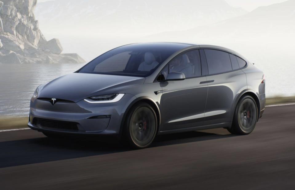 A gray Tesla Model X SUV drives down a road.