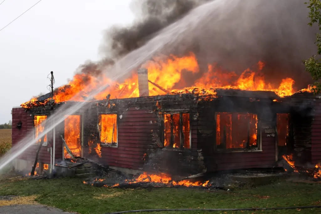 A house up in flames with firefighters in action, like that in Jasper, where a dog recently perished in a Texas house fire.